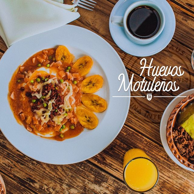 🍳 Deliciosos Huevos Motuleños con frijoles, cubiertos en salsa roja, chorizo...